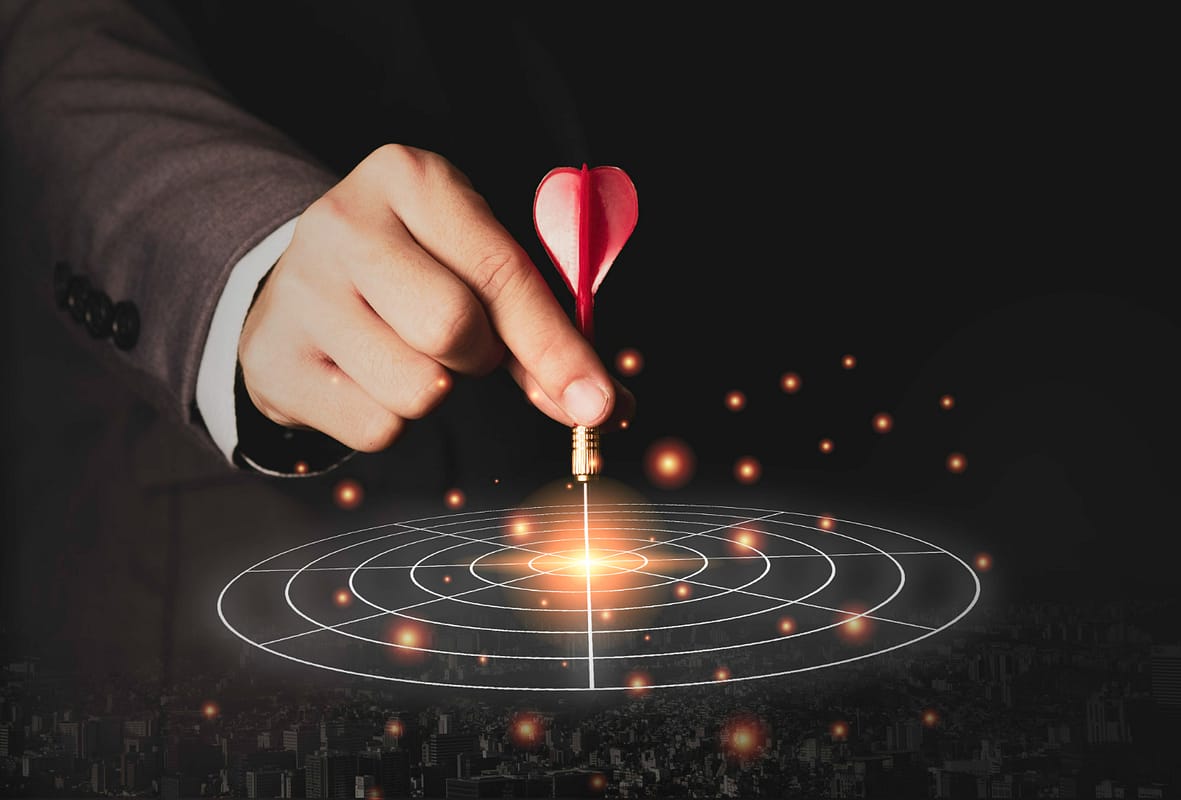 Photo executive marketing hand holding red dart put to centre of the target board. business investment goal and target